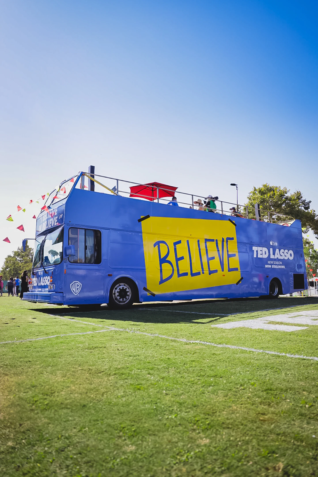 A big blue bus with a huge yellow sign saying