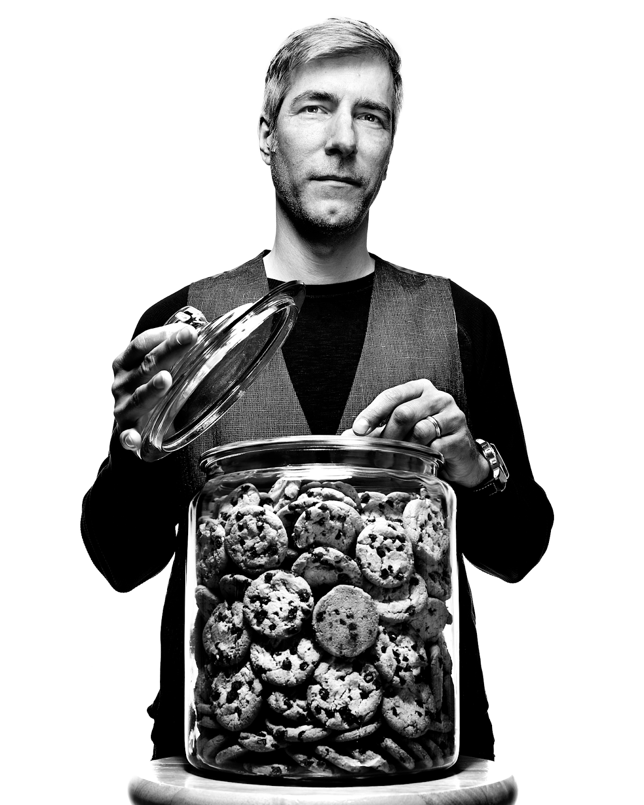 Lou Montulli standing in front of a large glass jar of cookies, lifting the lid off of it.