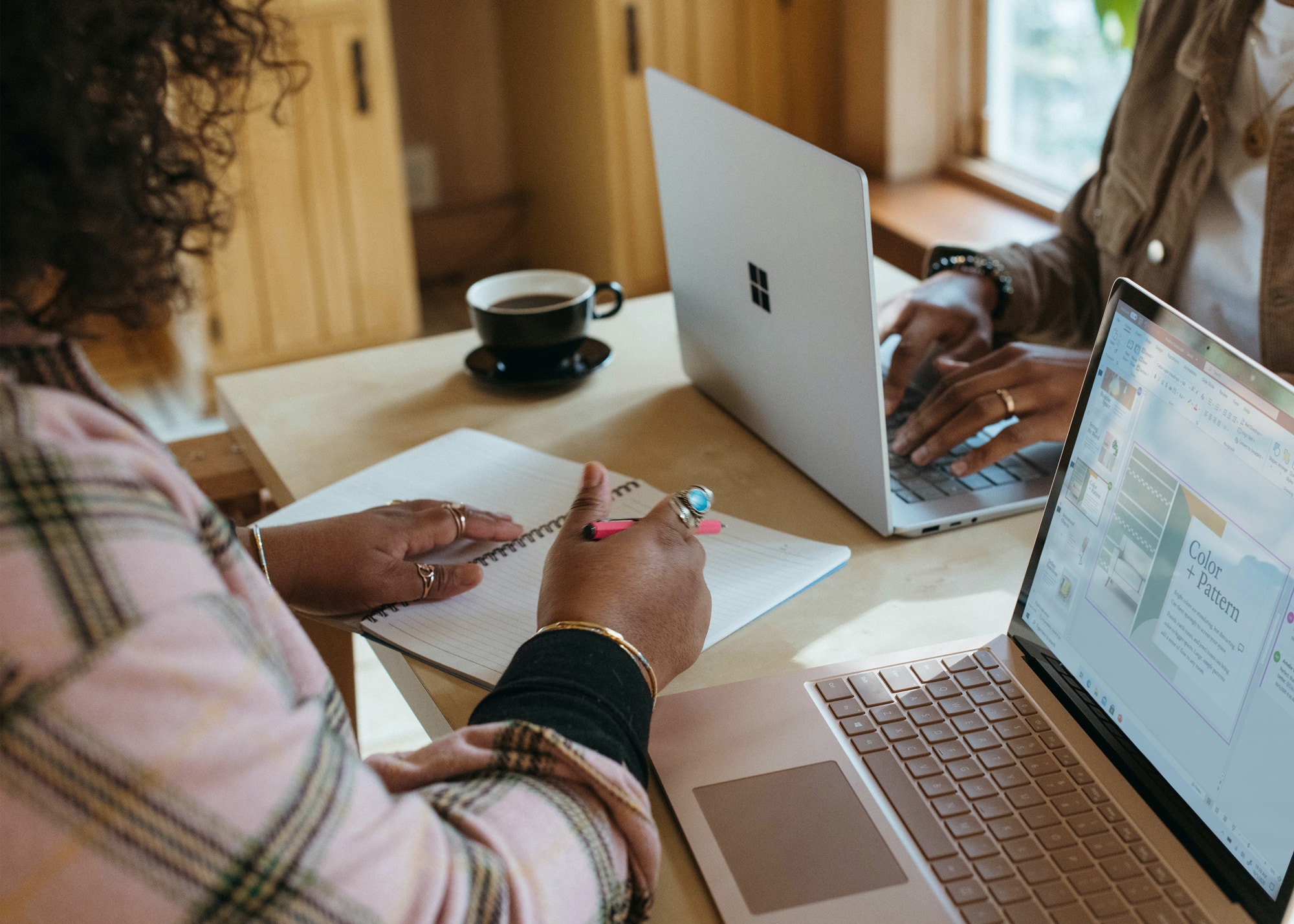Two designers sitting at a table with their laptops. 
