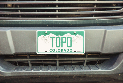A license plate reading 'Topo' on the front of an SUV. 