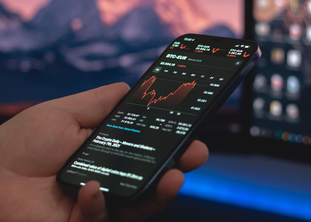 A person holding a smartphone showing the market price for Bitcoin in Europe. 