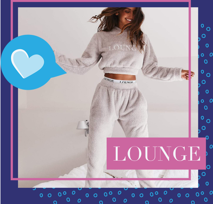 A woman jumping joyfully on a soft bed, wearing comfortable fuzzy Lounge Underwear crop top and sweats. 