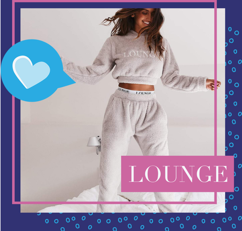 A woman jumping joyfully on a soft bed, wearing comfortable fuzzy Lounge Underwear crop top and sweats.
